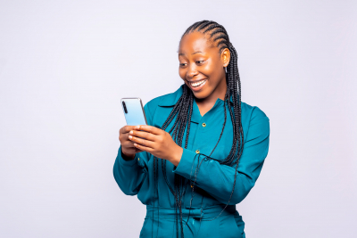 woman smiling while using her phone